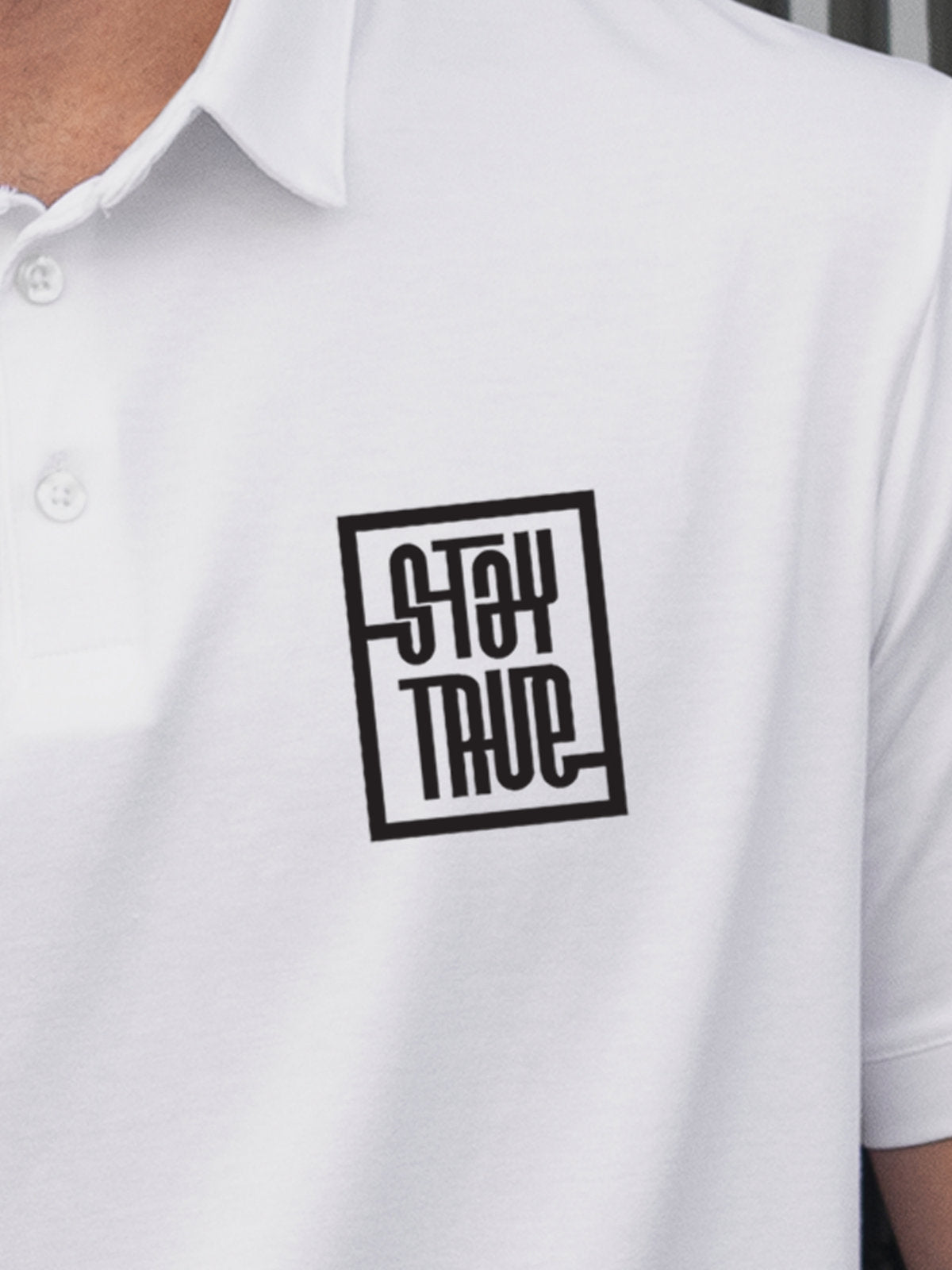 Close up of 'Stay True' on Men's White Polo T-shirt, highlighting intricate details and vibrant print.