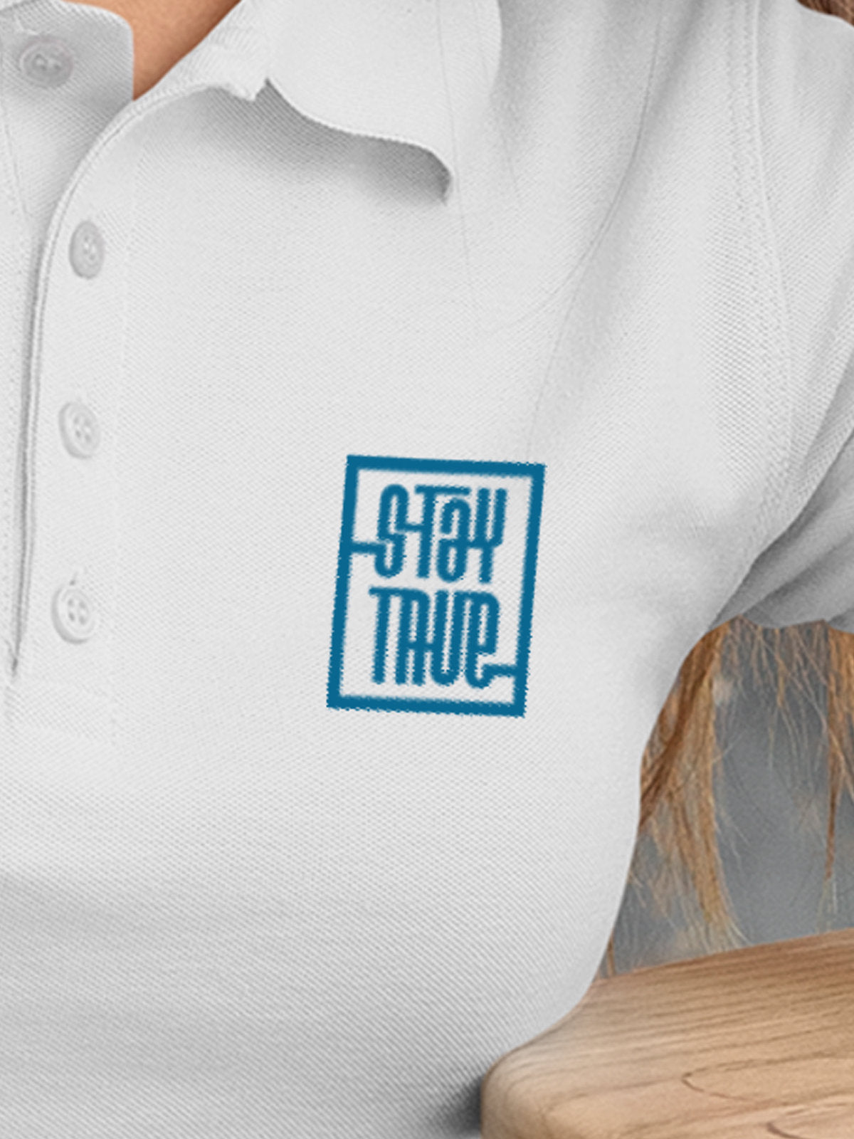 Close up of 'Stay True' on Women's White Polo T-shirt, highlighting intricate details and vibrant print.