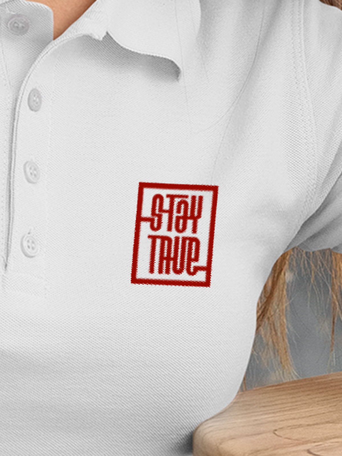 Close up of 'Stay True' on Women's White Polo T-shirt, highlighting intricate details and vibrant print.