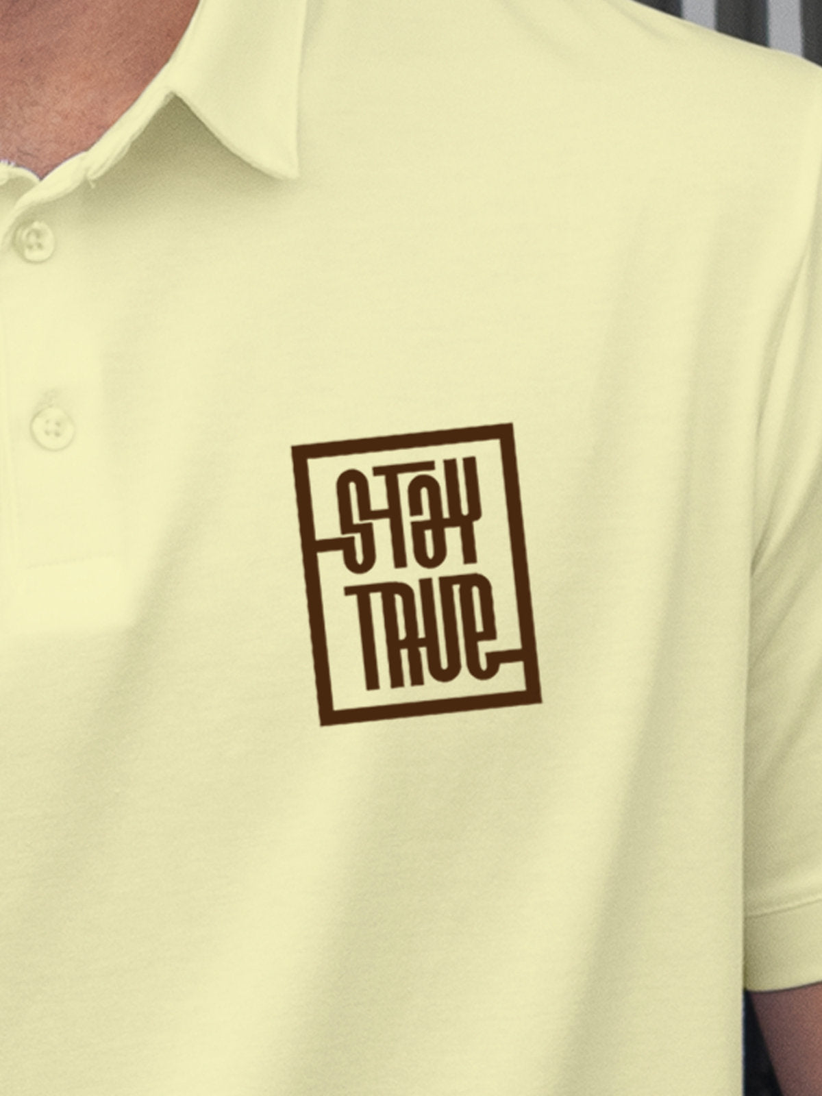Close up of 'Stay True' on Men's Yellow Polo T-shirt, highlighting intricate details and vibrant print.