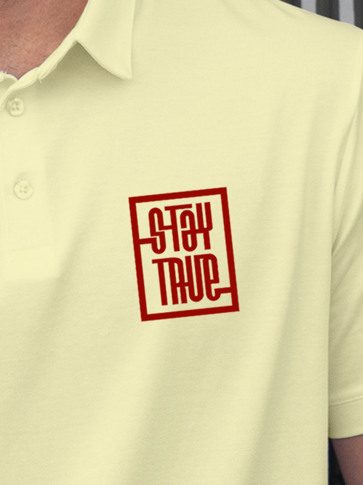 Close up of 'Stay True' on Men's Yellow Polo T-shirt, highlighting intricate details and vibrant print.