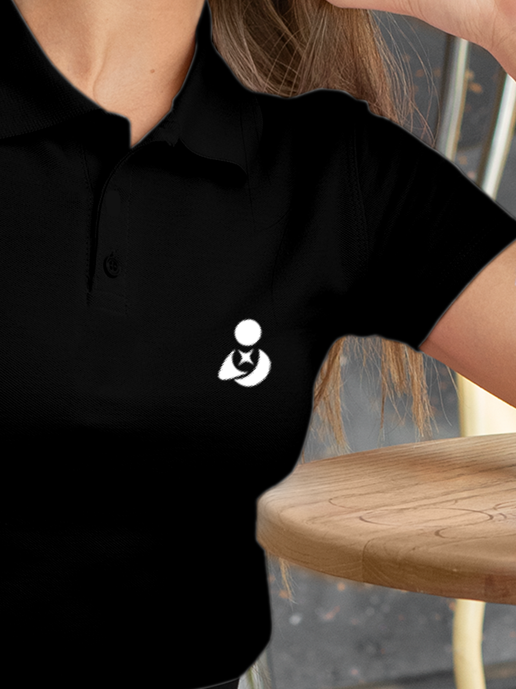 Close up of 'Fighterhero Logo' on Women's Black Polo T-shirt, highlighting intricate details and vibrant print.