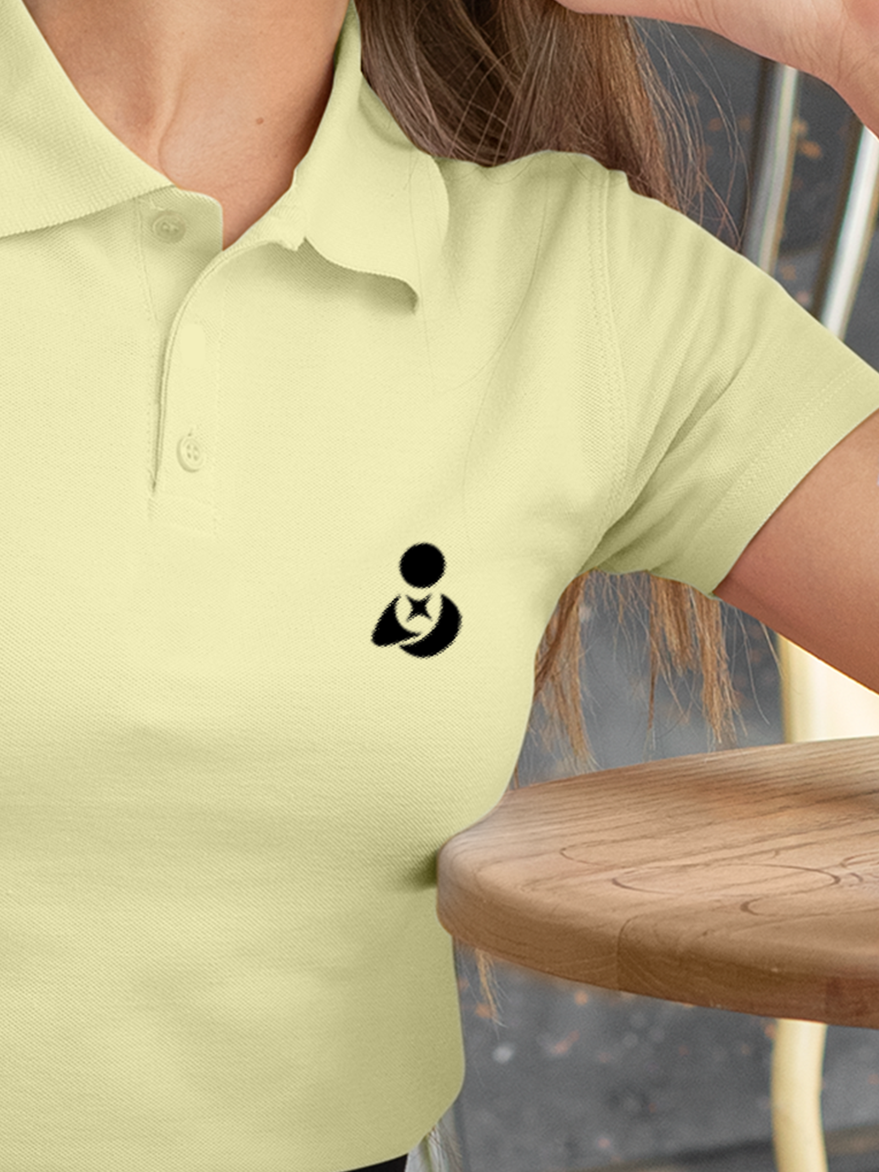 Close up of 'Fighterhero Logo' on Women's Yellow Polo T-shirt, highlighting intricate details and vibrant print.
