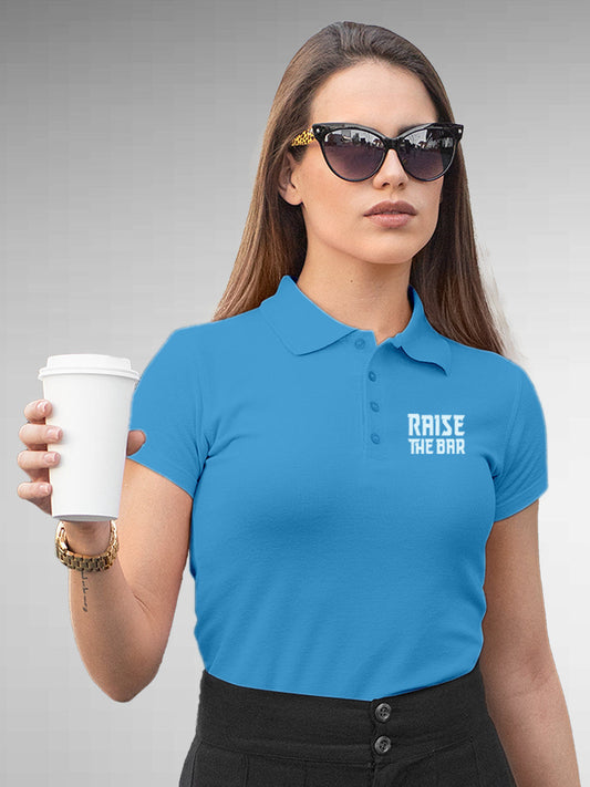 Model wearing Women's Blue Polo T-shirt with 'Raise The Bar' design, offering effortless style and premium comfort