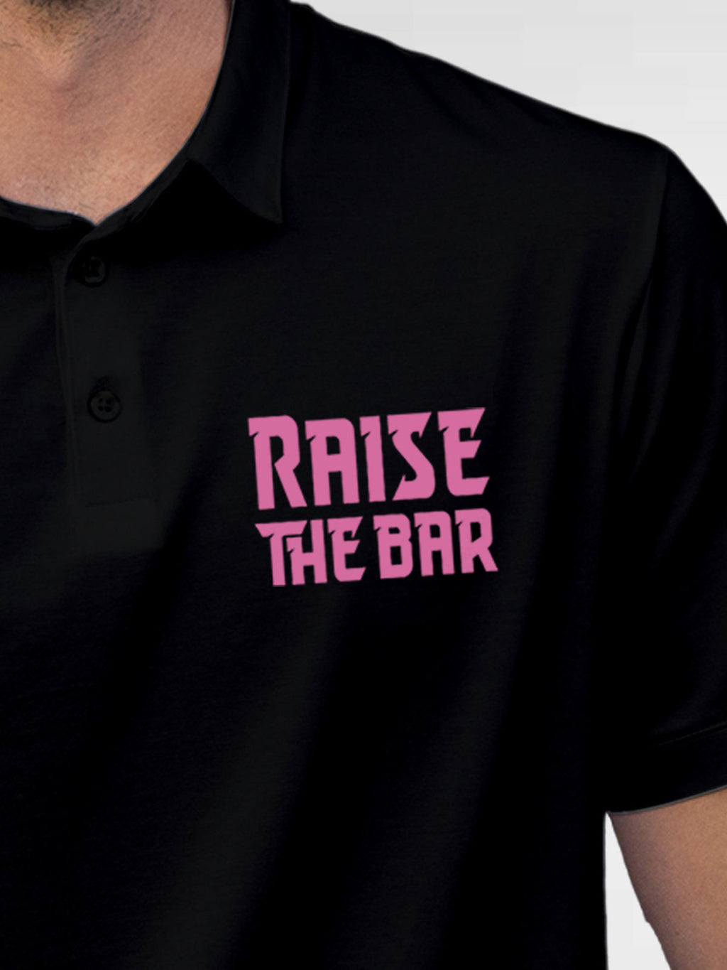 Close up of 'Raise The Bar' design on Men's Black Polo T-shirt, highlighting intricate details and vibrant print.