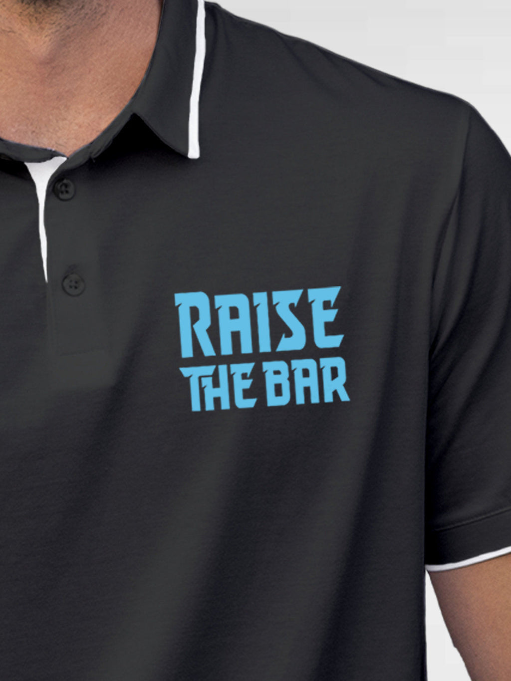 Close up of 'Raise The Bar' design on Men's Dark Grey Polo T-shirt, highlighting intricate details and vibrant print.