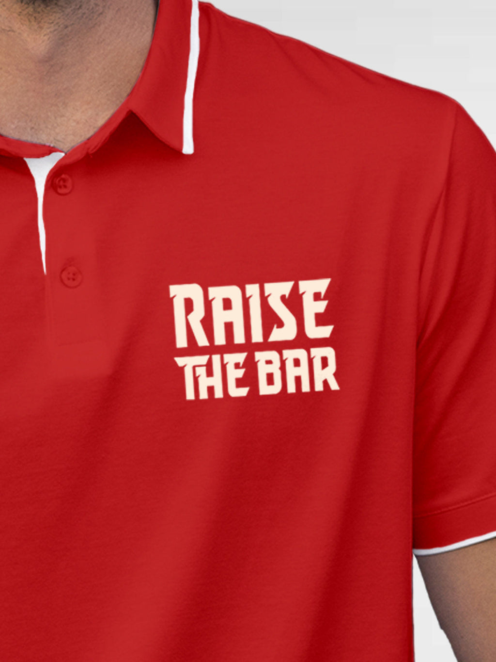 Close up of 'Raise The Bar' design on Men's Red Polo T-shirt, highlighting intricate details and vibrant print.