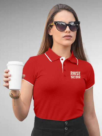 Model wearing Women's Red Polo T-shirt with 'Raise The Bar' design, offering effortless style and premium comfort