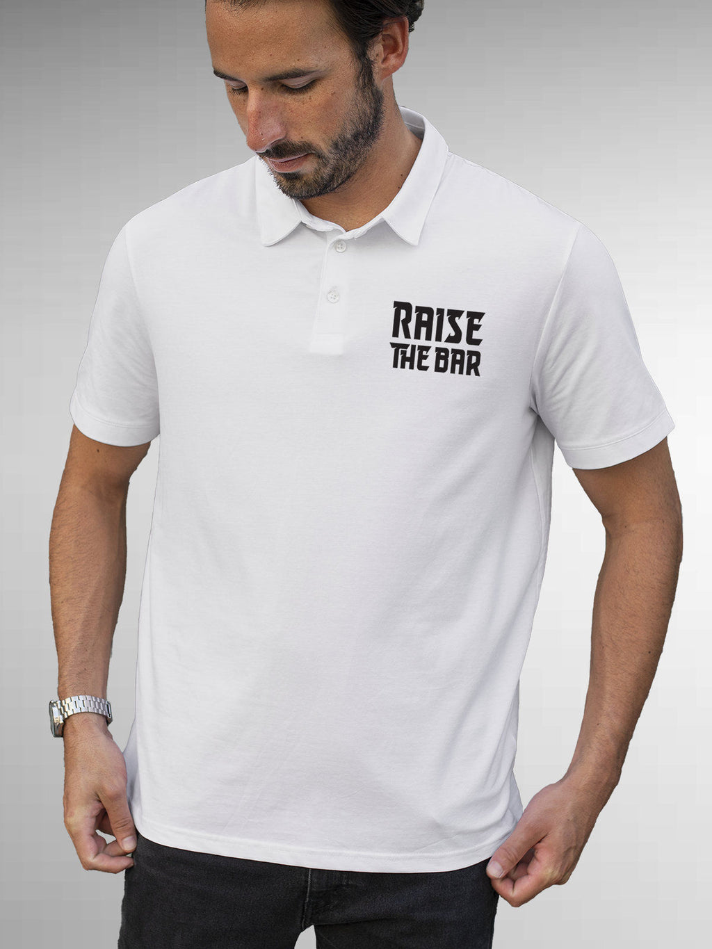 Model wearing Men's White Polo T-shirt with 'Raise The Bar' design, offering effortless style and premium comfort