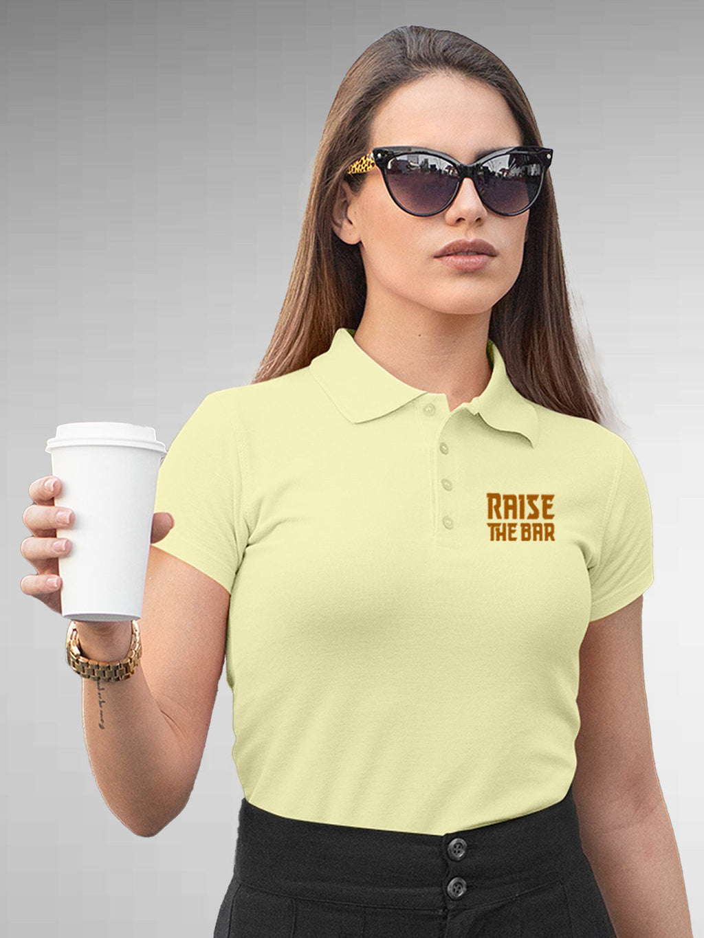 Model wearing Women's Yellow Polo T-shirt with 'Raise The Bar' design, offering effortless style and premium comfort