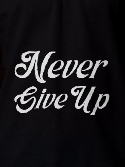 Close up of 'Never Give Up' design on Men's Black Polo T-shirt, highlighting intricate details and vibrant print.