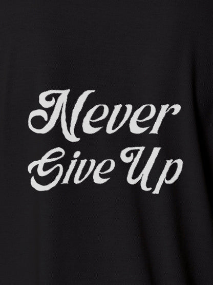 Close up of 'Never Give Up' design on Women's Dark Grey Polo T-shirt, highlighting intricate details and vibrant print.
