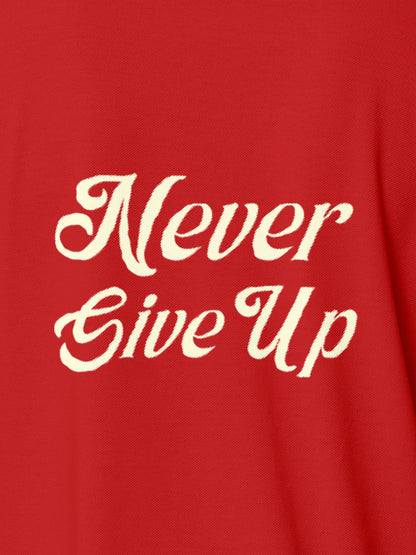 Close up of 'Never Give Up' design on Women's Red Polo T-shirt, highlighting intricate details and vibrant print.