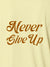 Close up of 'Never Give Up' design on Women's Yellow Polo T-shirt, highlighting intricate details and vibrant print.