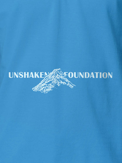 Close up of 'Unshaken Foundation' design on Women's Blue Polo T-shirt, highlighting intricate details and vibrant print.