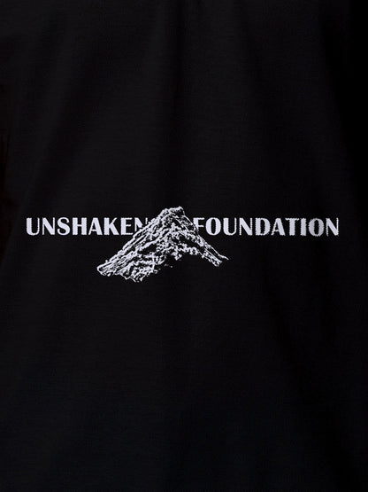 Close up of 'Unshaken Foundation' design on Women's Black Polo T-shirt, highlighting intricate details and vibrant print.
