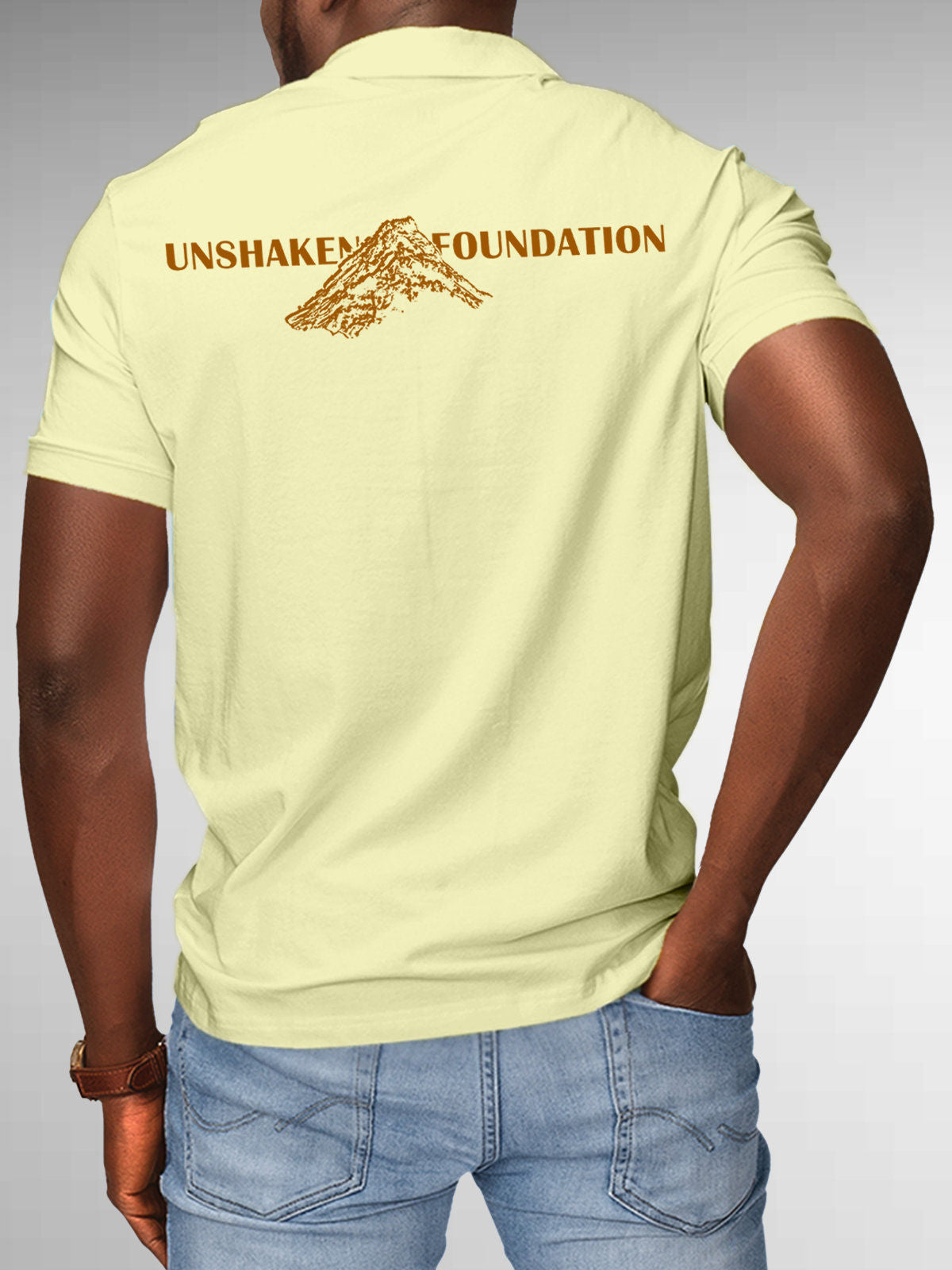 Model wearing Men's Yellow Polo T-shirt with 'Unshaken Foundation' design, offering effortless style and premium comfort