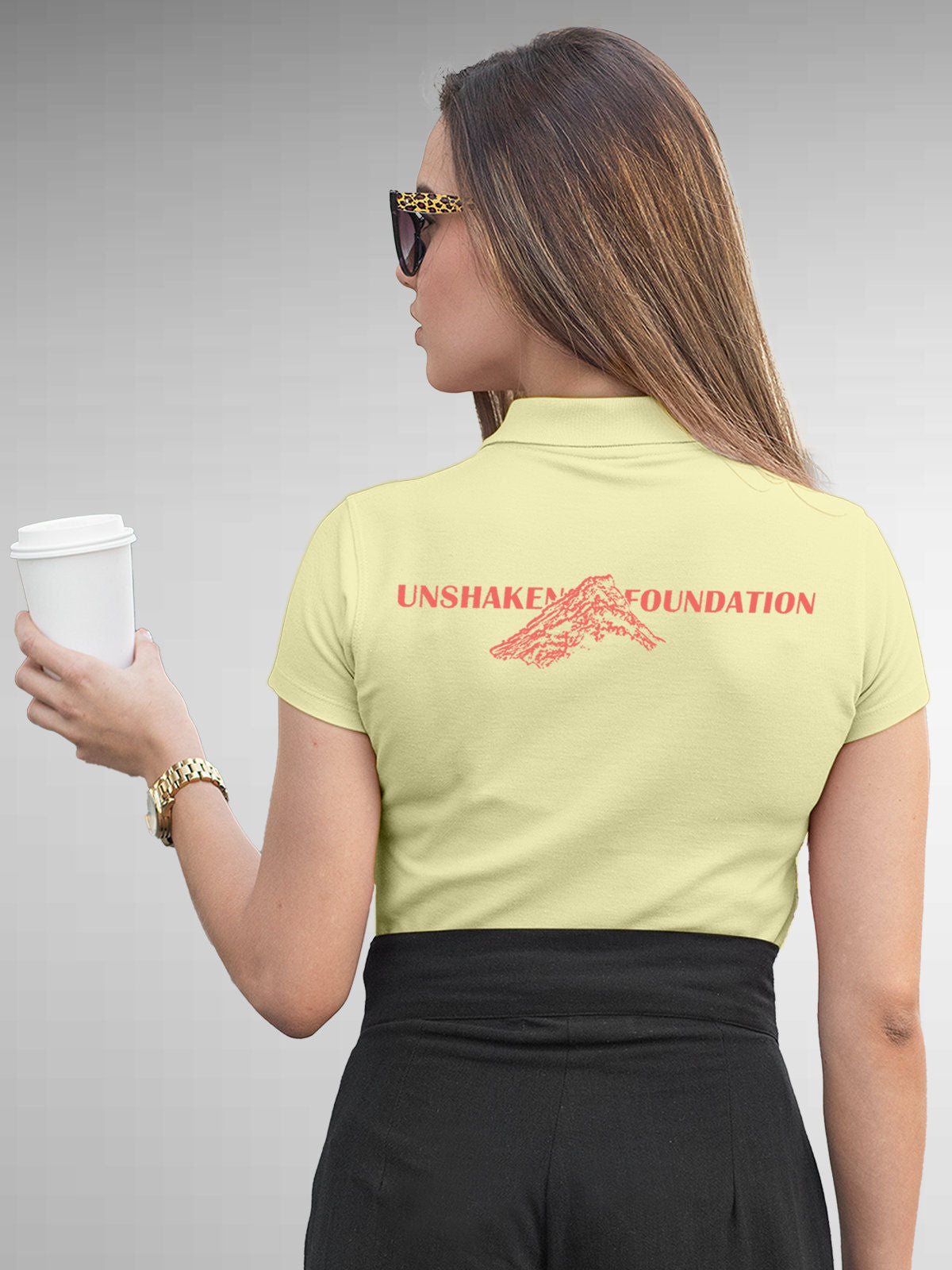 Model wearing Women's Yellow Polo T-shirt with 'Unshaken Foundation' design, offering effortless style and premium comfort