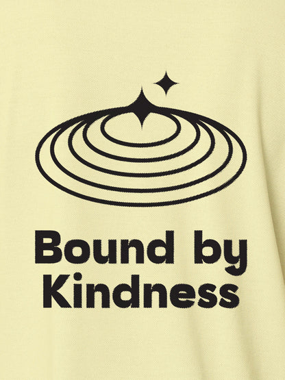 Close up of 'Bound By Kindness' design on Women's Yellow Polo T-shirt, highlighting intricate details and vibrant print.