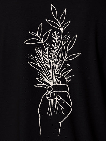 Close up of 'Love and Joy' design on Men's Black Polo T-shirt, highlighting intricate details and vibrant print.