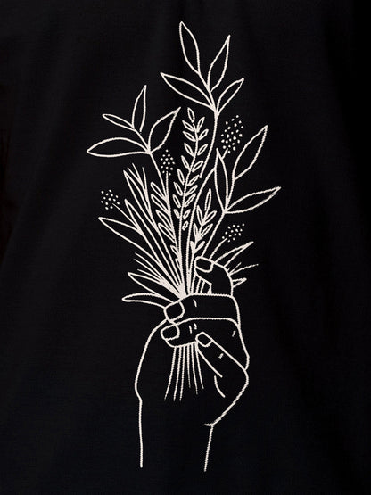 Close up of 'Love and Joy' design on Women's Black Polo T-shirt, highlighting intricate details and vibrant print.