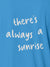 Close up of 'There's Always a Sunrise' design on Women's Blue Polo T-shirt, highlighting intricate details and vibrant print.