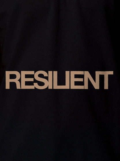 Close up of 'Resilient' design on Women's Black Polo T-shirt, highlighting intricate details and vibrant print.