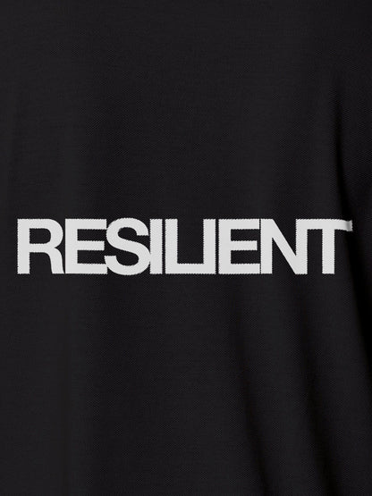 Close up of 'Resilient' design on Men's Dark Grey Polo T-shirt, highlighting intricate details and vibrant print.