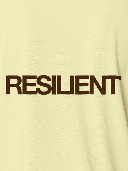 Close up of 'Resilient' design on Men's Yellow Polo T-shirt, highlighting intricate details and vibrant print.