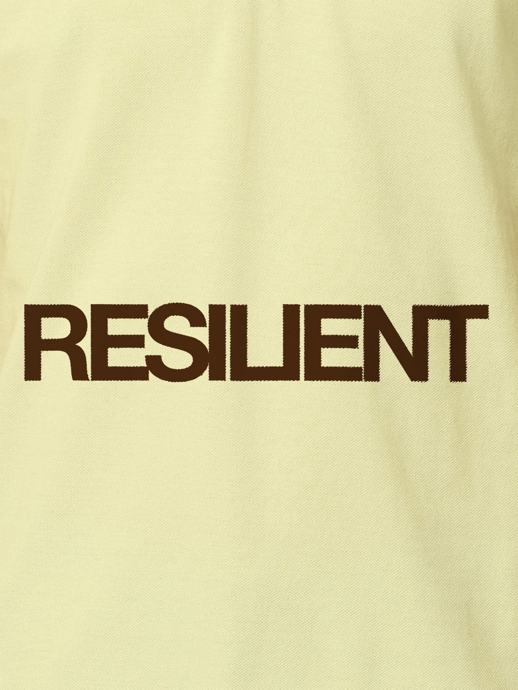 Close up of 'Resilient' design on Women's Yellow Polo T-shirt, highlighting intricate details and vibrant print.
