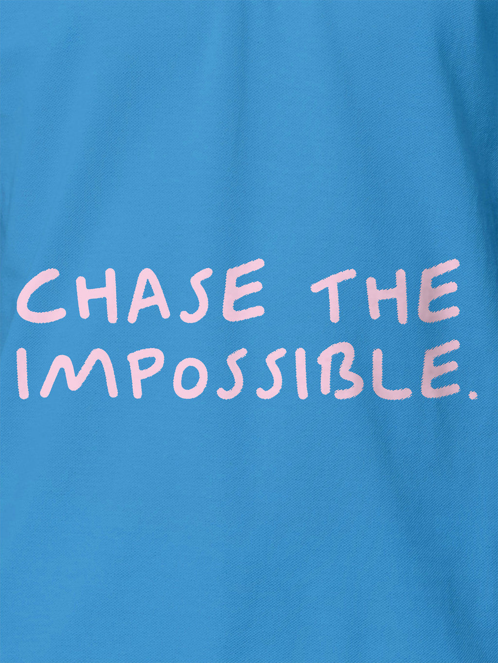 Close up of 'Chase The Impossible' design on Women's Blue Polo T-shirt, highlighting intricate details and vibrant print.
