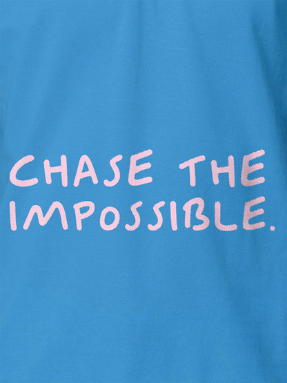 Close up of 'Chase The Impossible' design on Women's Blue Polo T-shirt, highlighting intricate details and vibrant print.