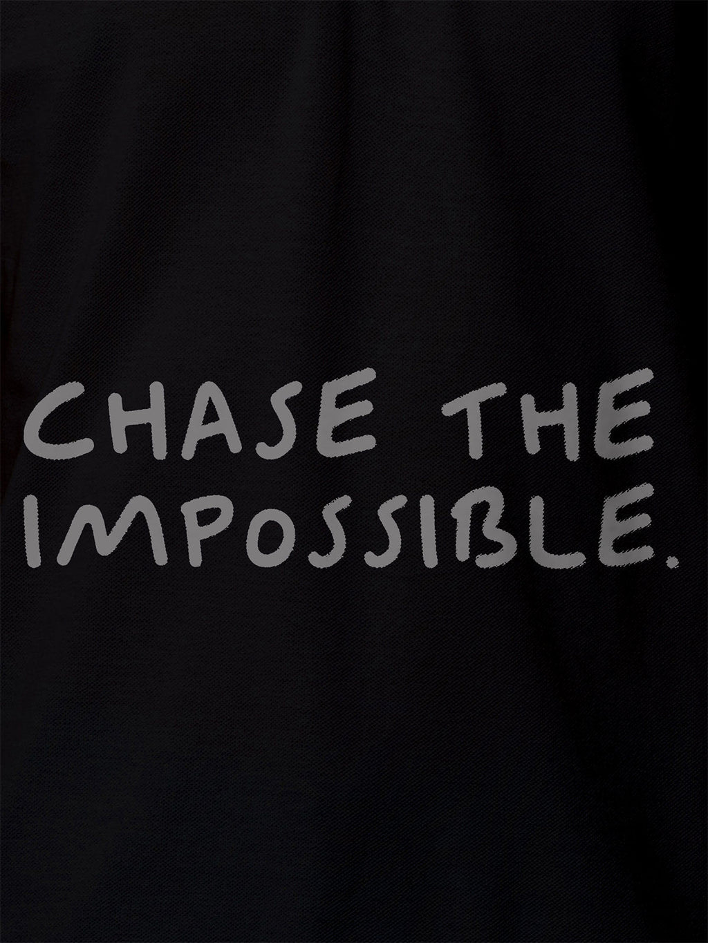 Close up of 'Chase The Impossible' design on Women's Black Polo T-shirt, highlighting intricate details and vibrant print.