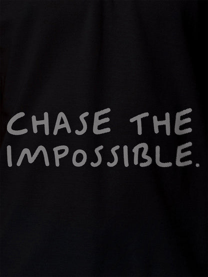 Close up of 'Chase The Impossible' design on Women's Black Polo T-shirt, highlighting intricate details and vibrant print.