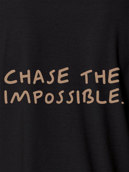 Close up of 'Chase The Impossible' design on Men's Dark Grey Polo T-shirt, highlighting intricate details and vibrant print.
