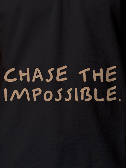 Close up of 'Chase The Impossible' design on Women's Dark Grey Polo T-shirt, highlighting intricate details and vibrant print.