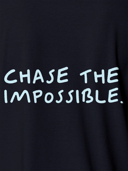Close up of 'Chase The Impossible' design on Men's Navy Blue Polo T-shirt, highlighting intricate details and vibrant print.