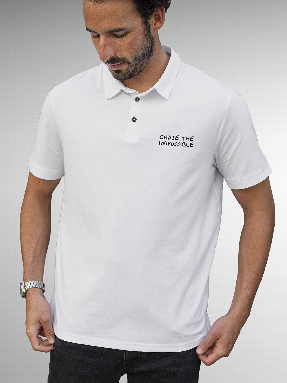 Model wearing Men's White Polo T-shirt with 'Chase The Impossible' design, offering effortless style and premium comfort