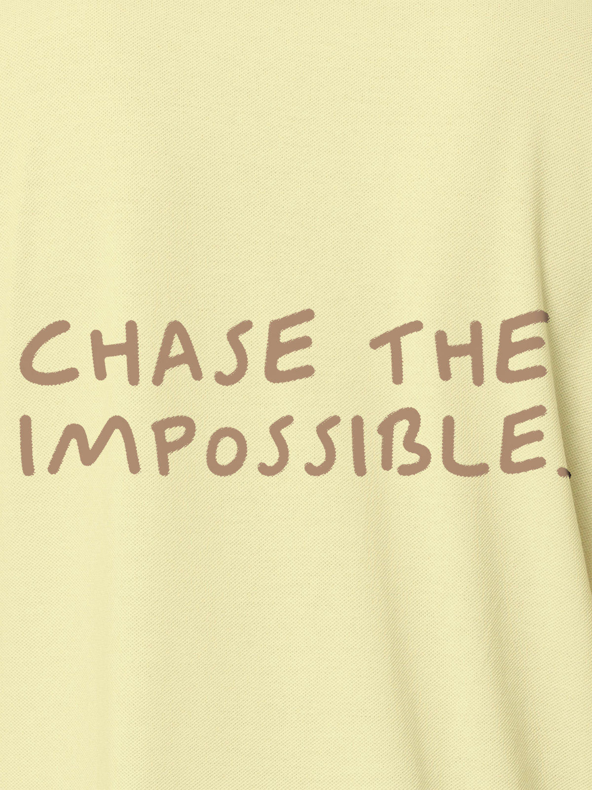Close up of 'Chase The Impossible' design on Men's Yellow Polo T-shirt, highlighting intricate details and vibrant print.