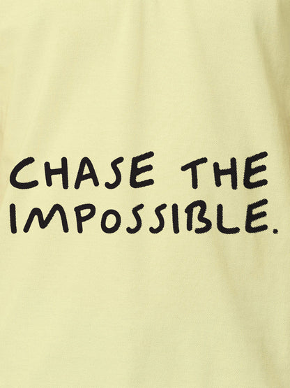 Close up of 'Chase The Impossible' design on Women's Yellow Polo T-shirt, highlighting intricate details and vibrant print.
